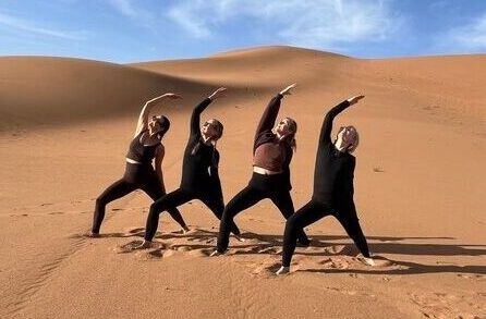 DesertChigagaTours - Desert Tours from Marrakech. Yoga Tours. Four women striking a yoga pose in ErgChigaga Sahara desert. Desert Tour from Marrakech. DesertChigagaTours.com